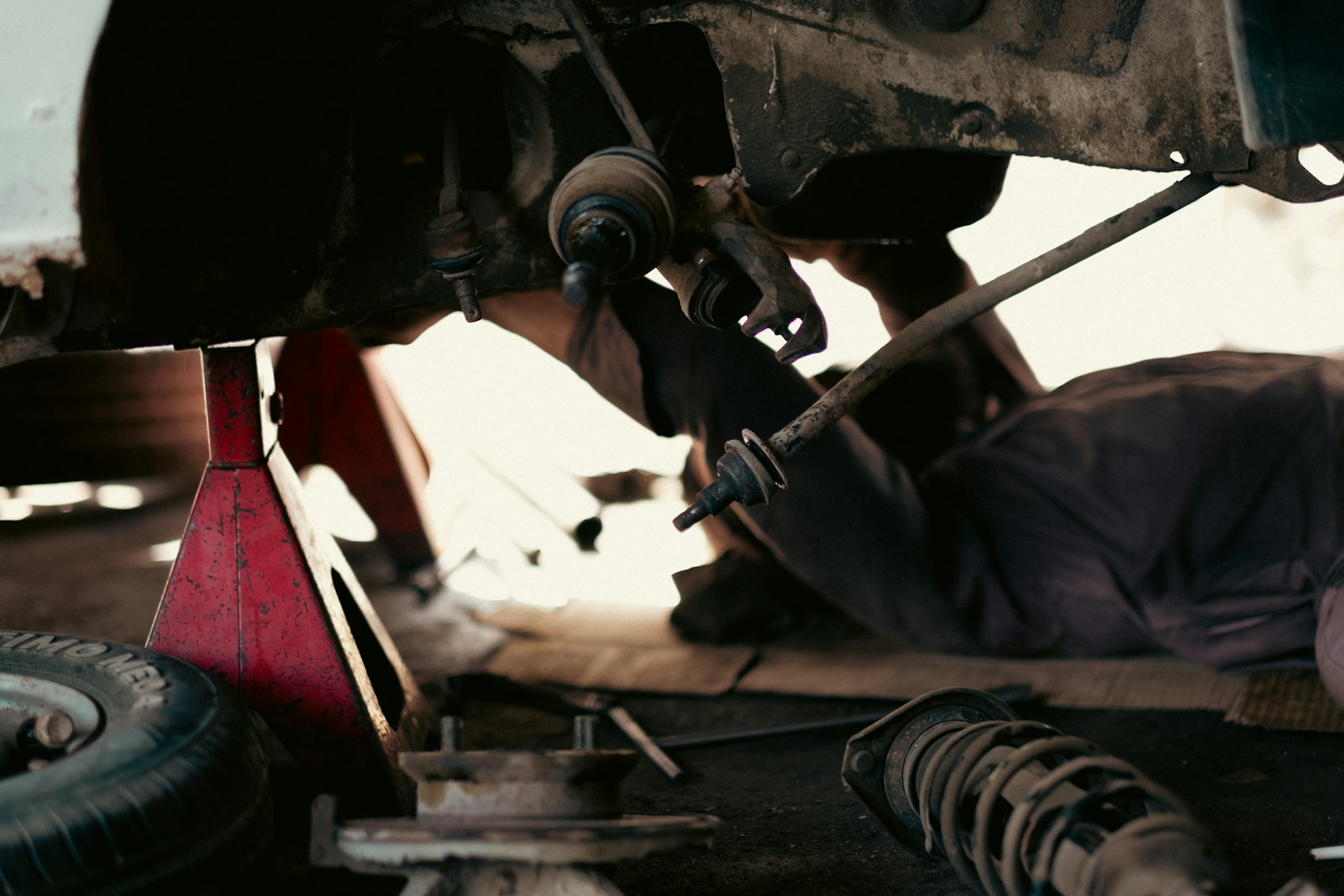 Mechanic performing undercarriage work on a vehicle
