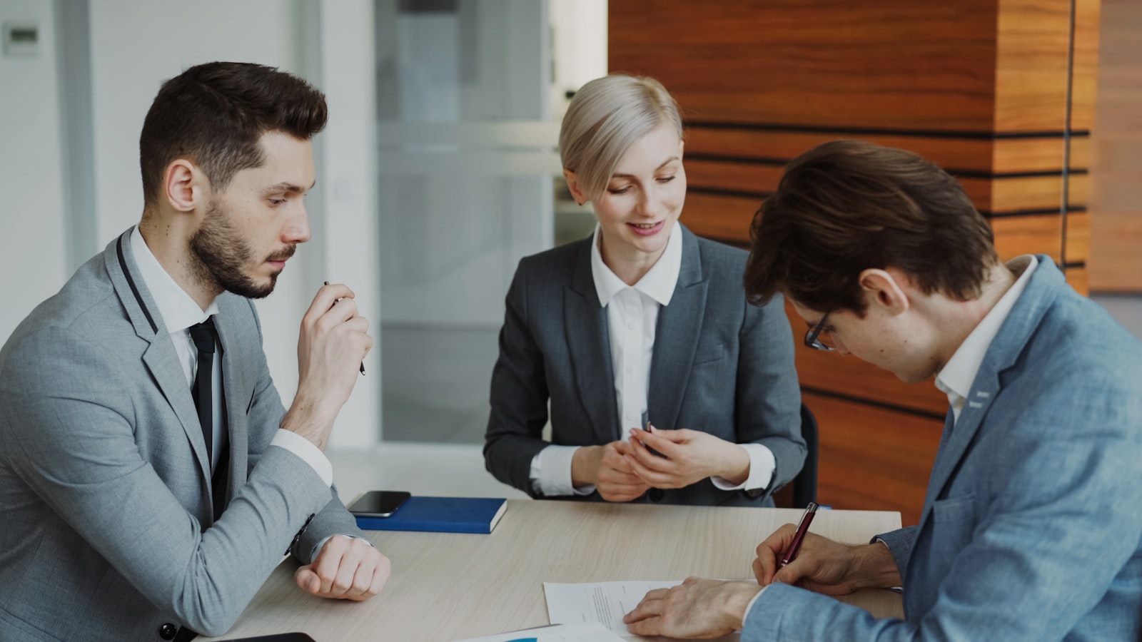 Lawyer and client signing a contract at a table